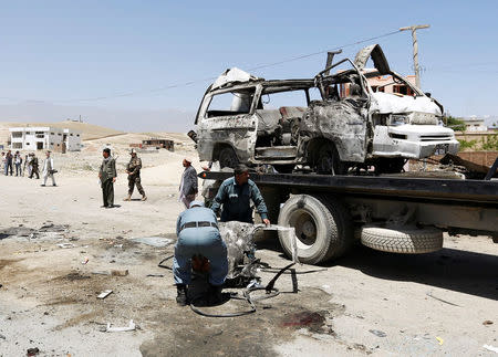 Afghan policemen work at the site of a suicide attack in west of Kabul, Afghanistan May 25, 2016. REUTERS/Mohammad Ismail