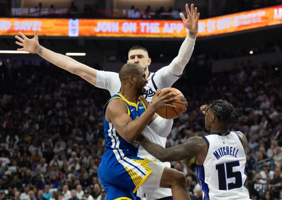 Golden State Warriors guard Chris Paul (3) is defended by Sacramento Kings guard Davion Mitchell (15) and center Alex Len (25) during an NBA play-in game at Golden 1 Center on Tuesday, April 16, 2024.