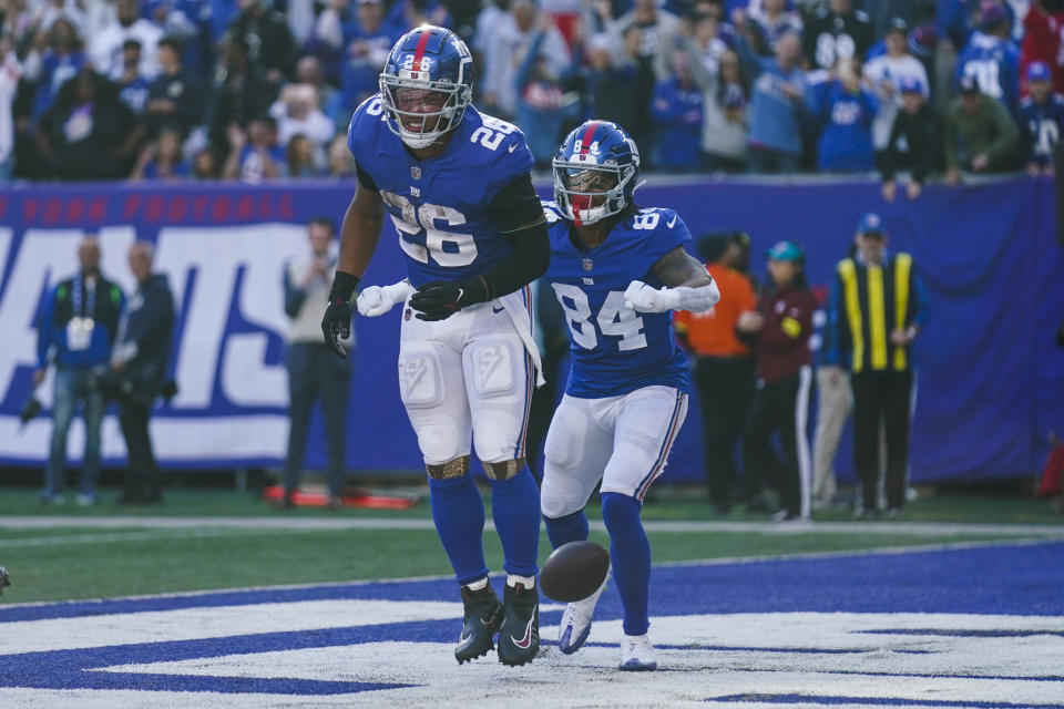 New York Giants' Saquon Barkley (26) celebrates with teammate Marcus Johnson (84) after scoring a touchdown during the second half of an NFL football game against the Baltimore Ravens, Sunday, Oct. 16, 2022, in East Rutherford, N.J. The Giants won 24-20. (AP Photo/Seth Wenig)