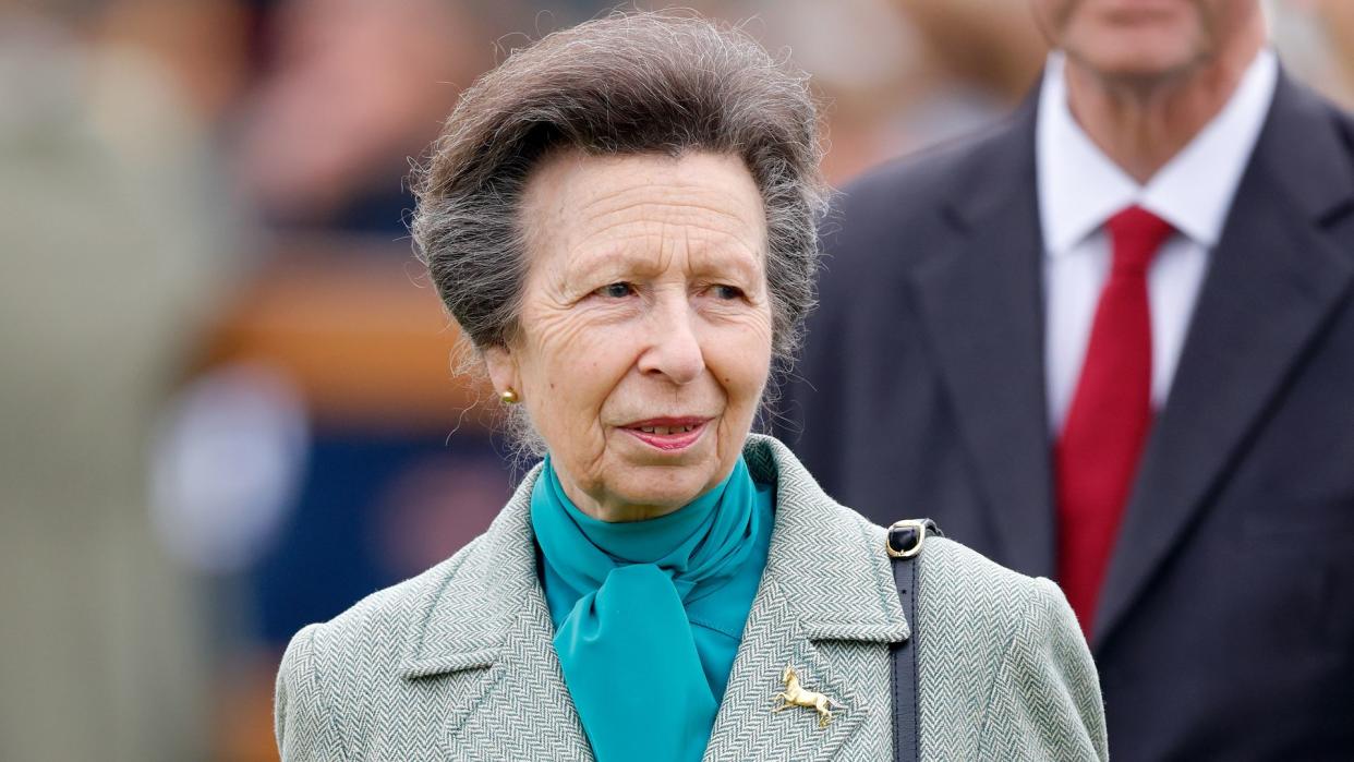 Princess Anne wearing turquoise blouse and green coat