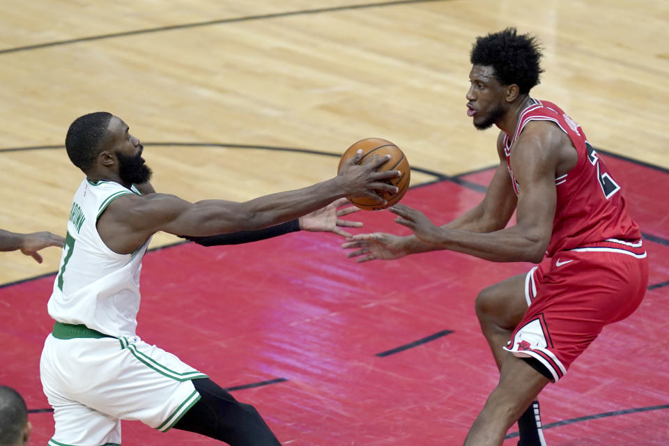 Boston Celtics' Jaylen Brown, left starts to lose control of the ball as Chicago Bulls' Thaddeus Young defends during the first half of an NBA basketball game Monday, Jan. 25, 2021, in Chicago. (AP Photo/Charles Rex Arbogast)