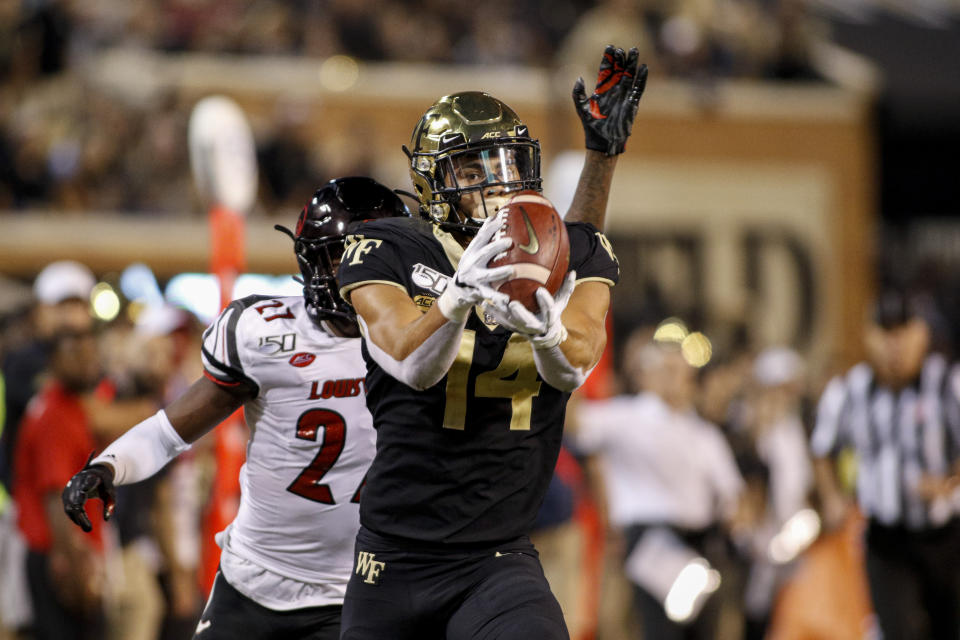 Wake Forest wide receiver Sage Surratt, front, scores on a 47-yard reception against Louisville during the second half of an NCAA college football game in Winston-Salem, N.C., Saturday, Oct. 12, 2019. Louisville won 62-59. (AP Photo/Nell Redmond)