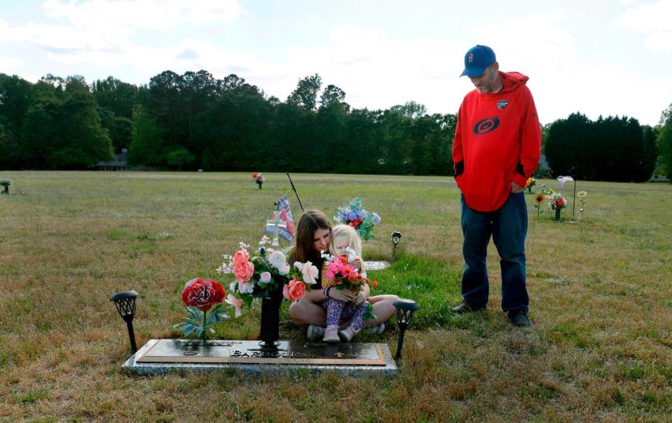 Van Barbour his daughters, Maddie, 12, and Oakleigh, 2, visit the grave of his wife and their mother who died from pregnancy-related complications in 2021. Ethan Hyman/ehyman@newsobserver.com
