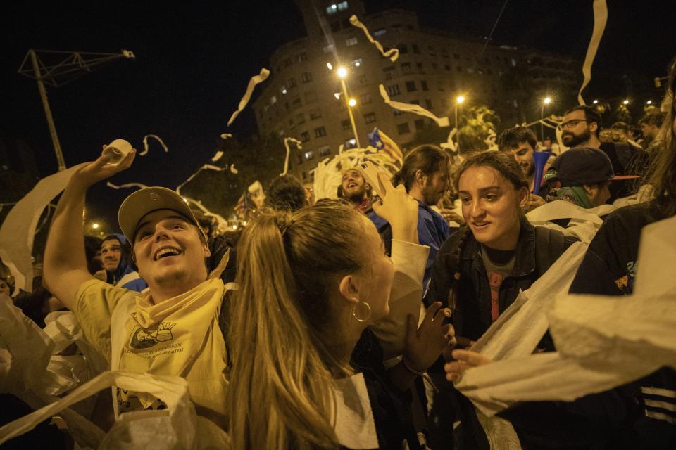 Catalan pro-independence demonstrators throw paper toilet rolls into the air during a protest in Barcelona Spain, Wednesday, Oct. 16, 2019. The Supreme Court found nine of 12 Catalan politicians and activists guilty of sedition and gave them prison sentences of nine to 13 years. Four of them were additionally convicted of misuse of public funds. The other three were fined for disobedience. (AP Photo/Bernat Armangue)