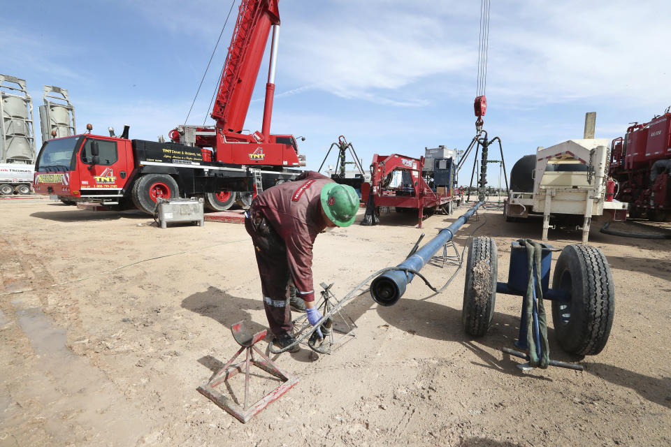 In a Monday, June 26, 2017 photo, Halliburton employees work at a three wellhead fracking site in Midland Texas. ( Steve Gonzales//Houston Chronicle via AP)