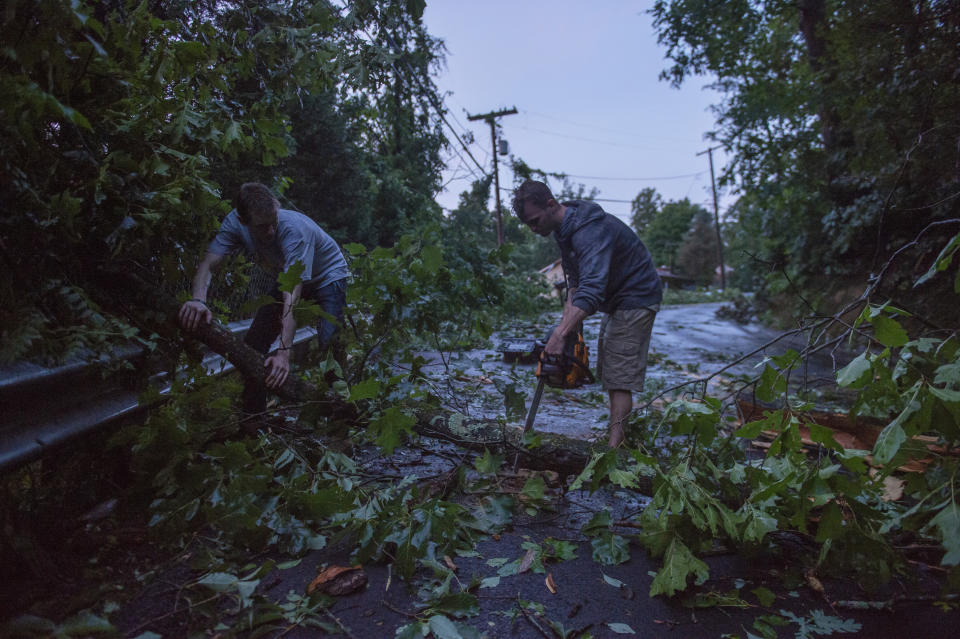 Peyton King, left, and Vince Staples clear debris from Hickory Road after a suspected tornado tore through Charleston, W.Va., Monday, June 24, 2019. (Craig Hudson/Charleston Gazette-Mail via AP)
