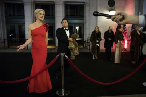 George Conway stands in the background as his wife Kellyanne Conway speaks to reporters at an event for President Donald Trump's 2017 inauguration