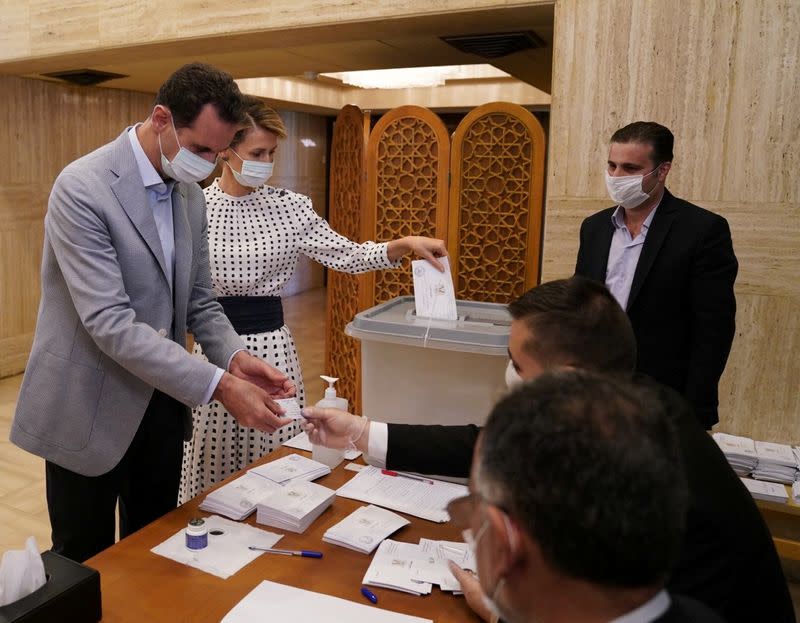 Syria's President Bashar al-Assad and his wife Asma cast their vote inside a polling station during the parliamentary elections in Damascus