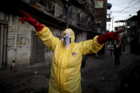 FILE - In this May 18, 2020 file photo, Jimena Aballe directs her neighbors as they disinfect their own streets in the Villa 31 neighborhood to curb the spread of COVID-19 in Buenos Aires, Argentina. Argentina reached 1 million confirmed coronavirus cases on Monday, Oct. 19, 2020, according to the Ministry of Health. (AP Photo/Natacha Pisarenko, File)