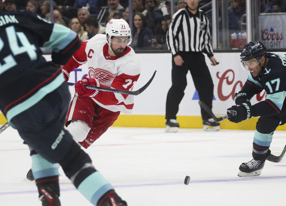 Detroit Red Wings center Dylan Larkin (71) moves the puck as Seattle Kraken center Jaden Schwartz (17) defends during the first period of an NHL hockey game Saturday, Feb. 18, 2023, in Seattle. (AP Photo/Lindsey Wasson)