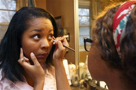 Lauren Thomas (R) applies makeup to her friend, Nita, in Nashville, Tennessee, December 20, 2013. REUTERS/Harrison McClary