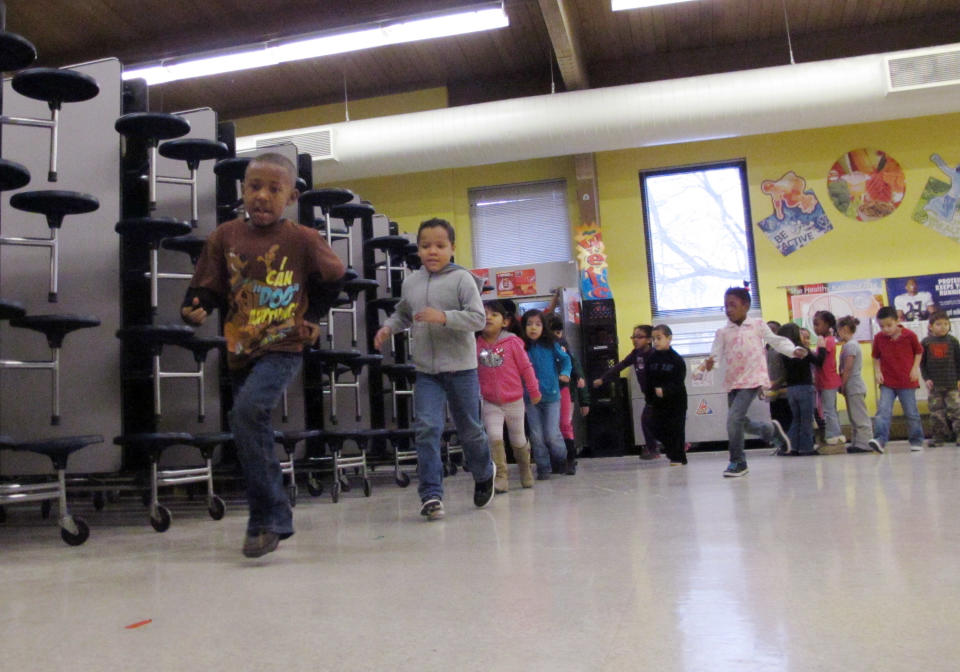 FILE - In this Jan. 9, 2014 photo kindergarten students run during a physical education class at Frank Rushton Elementary School, which has a high percentage of poor/at-risk kids, in Kansas City, Kan. On Friday, March 7, 2014, the Kansas Supreme Court said the state's current public school funding levels are unconstitutional and the state's poor school districts were harmed when the is made the decision to cut certain payments when tax revenues declined during the Great Recession. (AP Photo/John Hanna, File)