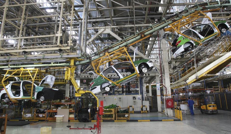 FILE - In this April 20, 2011 file photo, a line of Peugeot 206's, containing its hatchback and sedan, are on the production line at the Iranian state-run Iran Khodro automobile manufacturing plant near Tehran, Iran. For many business leaders, Iran is a mouthwatering emerging market, and they could soon find themselves heading to Iran to secure new deals following the suspension of the first international sanctions. (AP Photo/Vahid Salemi, File)