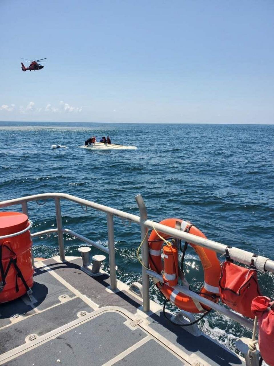 In this photo released by the U.S. Coast Guard, members of the Coast Guard rescue a family of four, Wednesday, Aug. 5, 2020, from a vessel taking on water 17 miles south of Southwest Pass near Venice, La. (U.S. Coast Guard via AP)