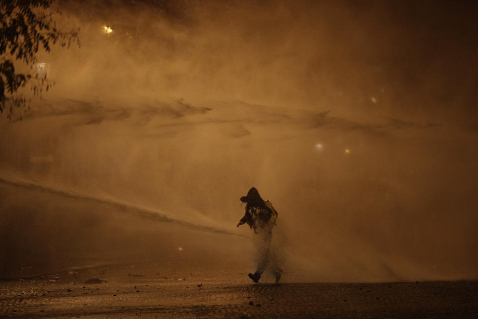 A demonstrator leaves as water cannons evacuate the Place de l’Etoile, near the Arc de Triomphe, Dec.1, 2018, in Paris. (Photo: Kamil Zihnioglu/AP)