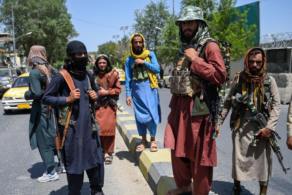 Taliban fighters stand guard along a street near Zanbaq Square in Kabul on August 16, 2021, after a stunningly swift end to Afghanistan's 20-year war, as thousands of people mobbed the city's airport trying to flee the group's feared hardline brand of Islamist rule. (Wakil Kohsar/AFP via Getty Images)