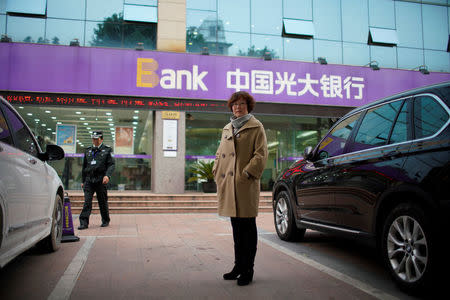 Anne Xing poses for pictures in front of the branch of China Everbright Bank in Shanghai, China, December 7, 2017. REUTERS/Aly Song