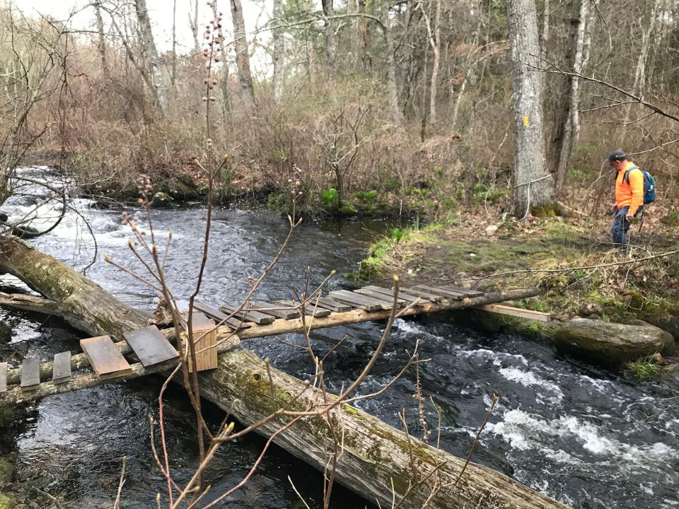 A wooden slat bridge crosses the tumbling waters of the Canonchet Brook in the Black Farm Management Area.