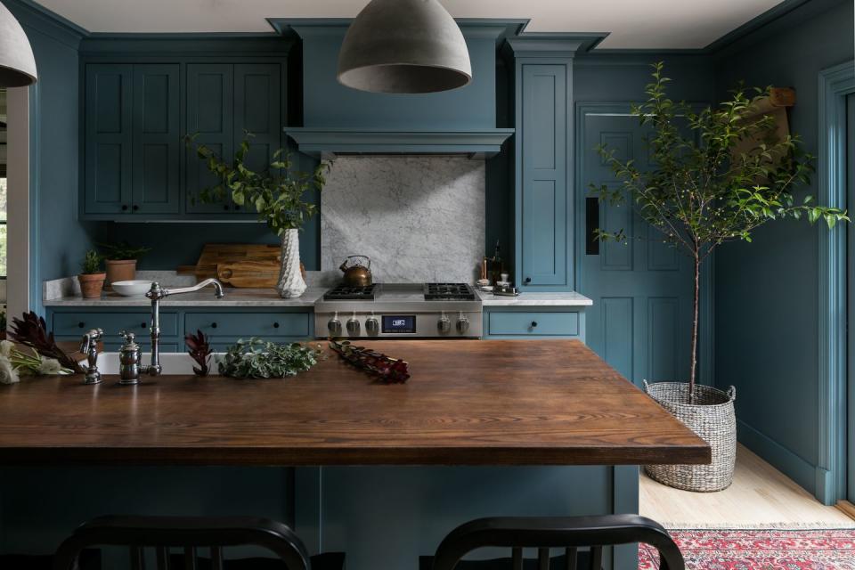 moody blue kitchen with butcher block island