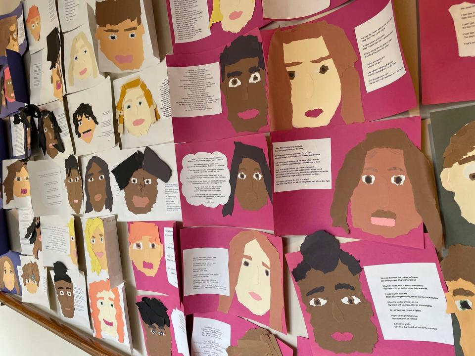 A display shows the work of middle school students inspired by Dunbar's poem "We Wear the Mask."