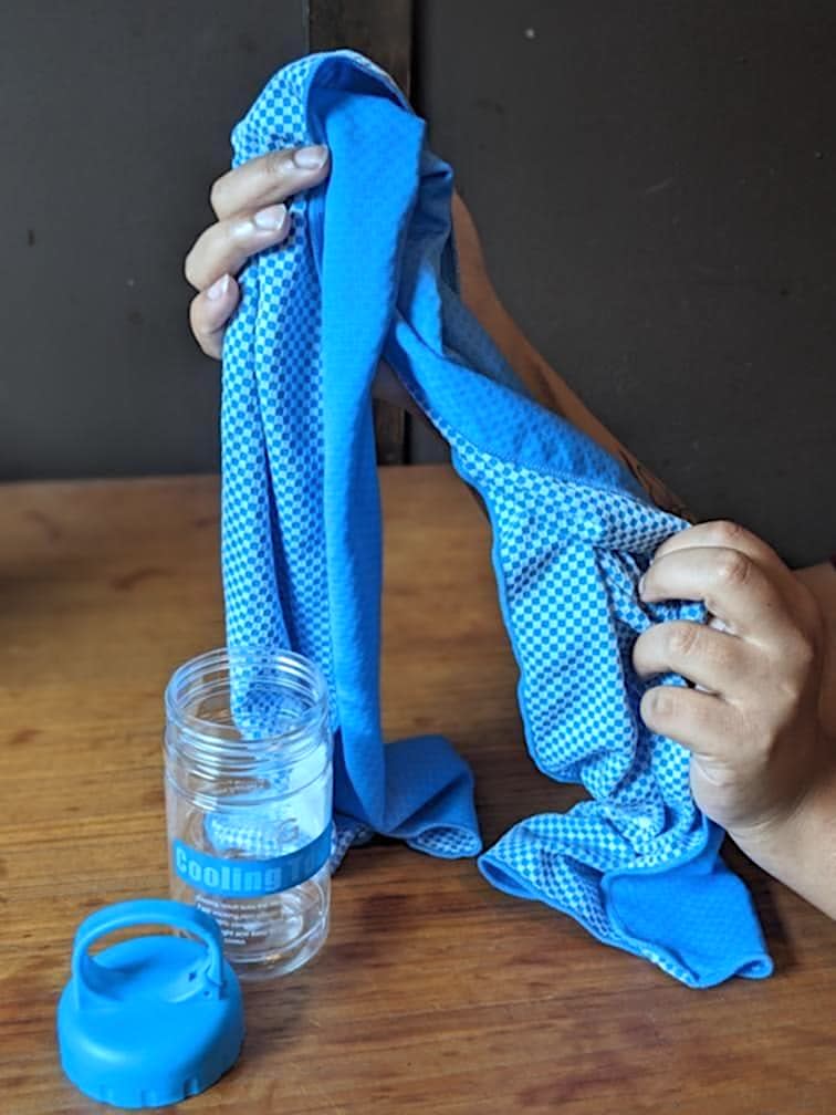 hands holding blue BOGI Cooling Towel and jar