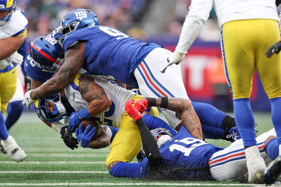 Dec 31, 2023; East Rutherford, New Jersey, USA; Los Angeles Rams running back Kyren Williams (23) is tackled by New York Giants linebacker Bobby Okereke (58) and defensive tackle Timmy Horne (96) during the second half at MetLife Stadium. Mandatory Credit: Vincent Carchietta-USA TODAY Sports