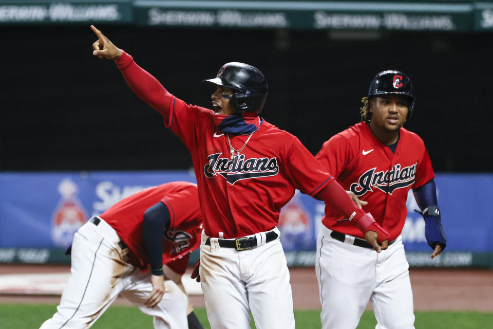 Cleveland Indians' Francisco Lindor, center, celebrates after scoring on a double by Domingo Santana off Detroit Tigers pitcher John Schreiber during the sixth inning of a baseball game, Saturday, Aug. 22, 2020, in Cleveland. (AP Photo/Ron Schwane)