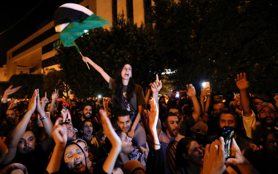 People gather during a protest after hundreds of Palestinians were killed in a blast at Al-Ahli hospital in Gaza that Israeli and Palestinian officials blamed on each other, in front of the French embassy in Tunis