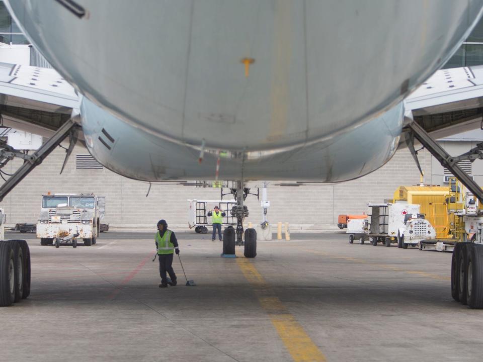 Workers under an Air Canada plane on the tarmac at Toronto Pearson International Airport. May 18, 2014.