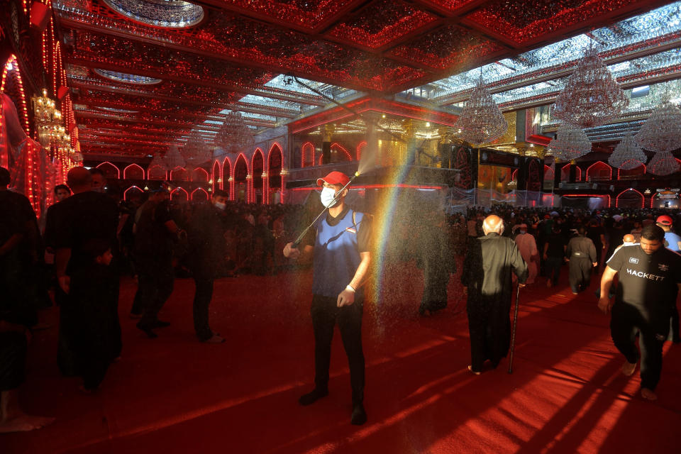 A health worker sprays disinfectant to sanitize the inside of the holy shrine of Imam Abbas during Muharram procession in Karbala, Iraq, Saturday, Aug. 29, 2020. Muharram, the first month of the Islamic calendar, is a month of mourning for Shiites in remembrance of the death of Hussein, the grandson of the Prophet Muhammad, at the Battle of Karbala in present-day Iraq in the 7th century.(AP Photo/Anmar Khalil)