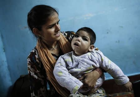 Three-year-old Abdul, who suffers from mental and physical disabilities plays with his mother Rukhsana at their house in Bhopal November 13, 2014. REUTERS/Danish Siddiqui