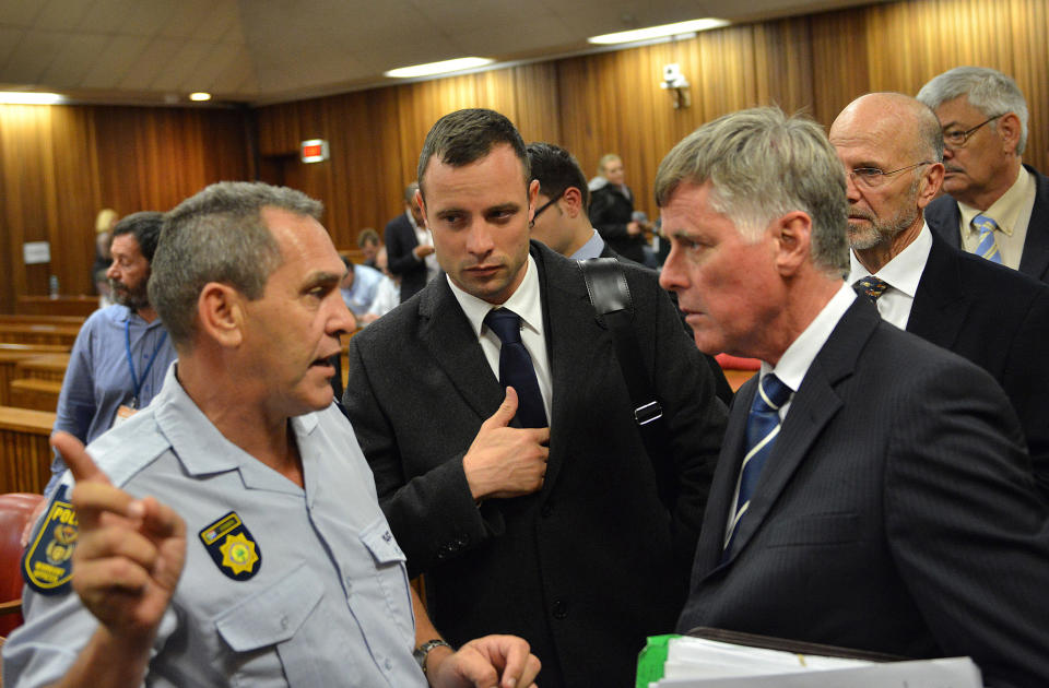 Oscar Pistorius, center, during a break inside court on the second day of his trial at the high court in Pretoria, South Africa, Tuesday, March 4, 2014. Pistorius is charged with murder for the shooting death of his girlfriend, Reeva Steenkamp, on Valentines Day in 2013. (AP Photo/Antoine de Ras, Pool)