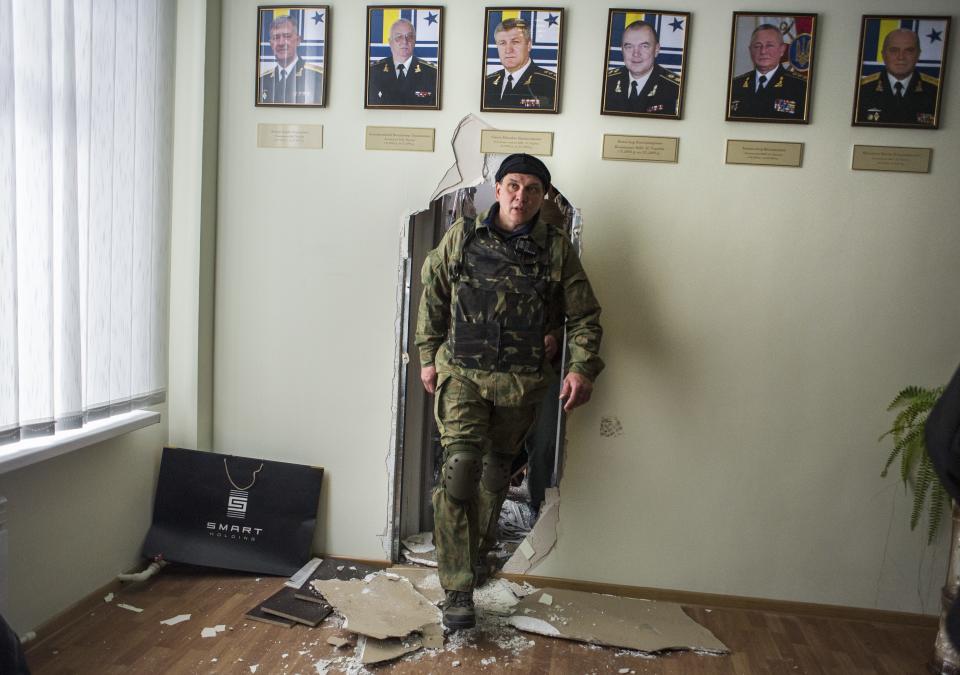 Crimean self-defense forces member walks in the Ukrainian navy headquarters in Sevastopol, Crimea, Wednesday, March 19, 2014. Crimea's self-defense forces on Wednesday stormed the Ukrainian navy headquarters in the Black Sea port of Sevastopol, taking possession without resistance a day after Russia signed a treaty with local authorities to annex the region. (AP Photo/Andrew Lubimov)