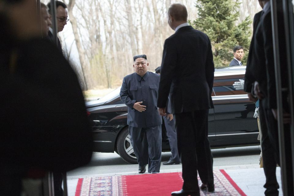 North Korea's leader Kim Jong Un, center, arrives for talks wit Russian President Vladimir Putin, back to a camera, in Vladivostok, Russia, Thursday, April 25, 2019. Putin and Kim are set to have one-on-one meeting at the Far Eastern State University on the Russky Island across a bridge from Vladivostok. The meeting will be followed by broader talks involving officials from both sides. (AP Photo/Alexander Zemlianichenko, Pool)