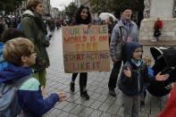 An Extinction Rebellion climate change protester holds a placard at the bottom of Trafalgar Square in London, Friday, Oct. 11, 2019. Some hundreds of climate change activists are in London during a fifth day of protests by the Extinction Rebellion movement to demand more urgent actions to counter global warming. (AP Photo/Matt Dunham)