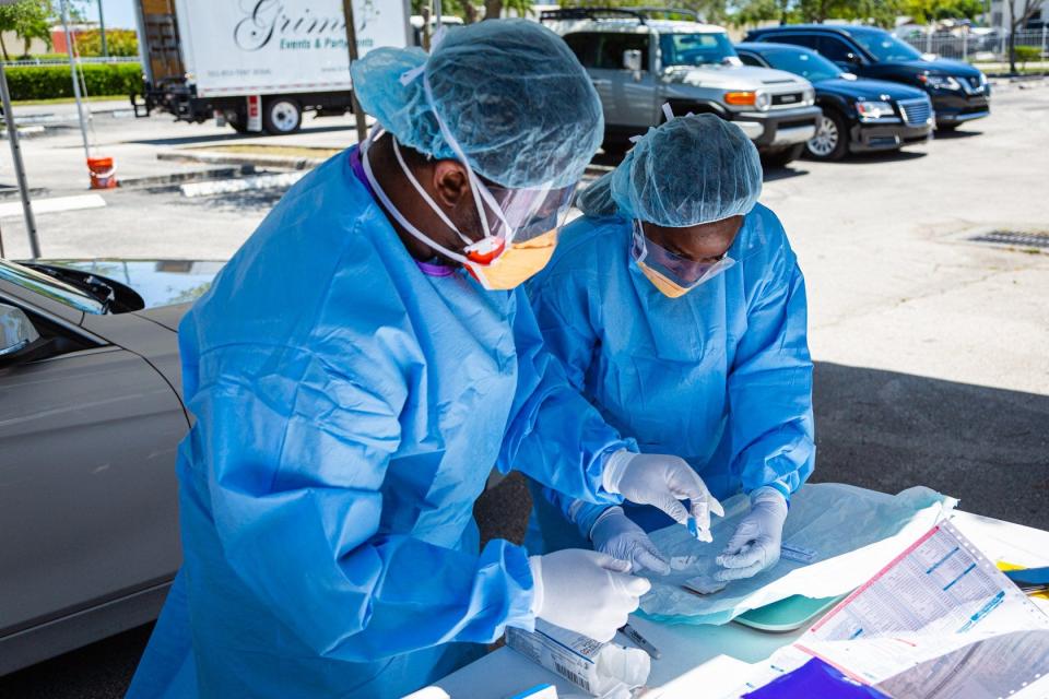 Medical assistants Nelson LaFrance, left, and Rosalyn James prepare a test kit at a new coronavirus testing site at the St. John Missionary Baptist Church on Seacrest Blvd. in Boynton Beach, Monday, May 4, 2020.
(Credit: Joe Forzano, The Palm Beach Post)