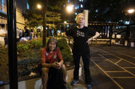 In this Oct. 9, 2020 photo, Grace Ma, right, chats with pro-democracy activist Leung Kwok-hung outside her bar Club 71 in Hong Kong. The bar known as a gathering place for pro-democracy activists and intellectuals is closing. For years, the storied bar has served as a watering hole for the city’s pro-democracy activists and intellectuals, who could freely engage in discussions over a round of beer or two. (AP Photo/Kin Cheung)