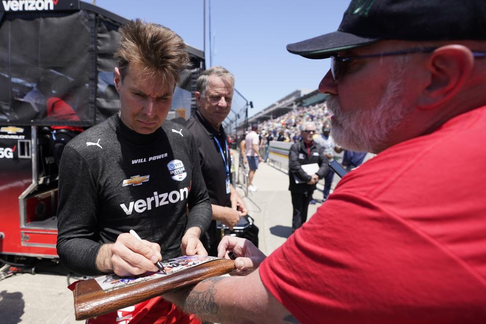 Will Power, of Australia, signs an autograph following the final practice for the Indianapolis 500 auto race at Indianapolis Motor Speedway, Friday, May 26, 2023, in Indianapolis. (AP Photo/Darron Cummings)