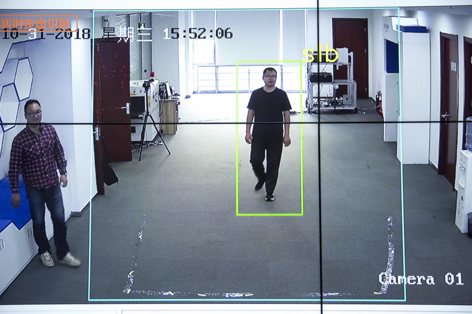 In this Oct. 31, 2018, photo, Watrix employees demonstrate their firm's gait recognition software at their company's offices in Beijing. A Chinese technology startup hopes to begin selling software that recognizes people by their body shape and how they walk, enabling identification when faces are hidden from cameras. Already used by police on the streets of Beijing and Shanghai, “gait recognition” is part of a major push to develop artificial-intelligence and data-driven surveillance across China, raising concern about how far the technology will go. (AP Photo/Mark Schiefelbein)