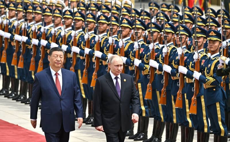Russian President Vladimir Putin (R) and Chinese President Xi Jinping inspect the guard of honour during a welcoming ceremony during a two-day state visit to China. -/Kremlin/dpa
