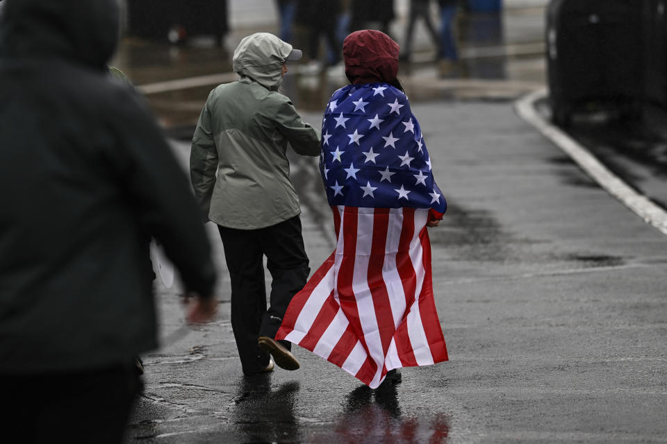 Race fans walk through the garage area while rain causes a delay of a NASCAR Cup Series auto race at Charlotte Motor Speedway Sunday, May 28, 2023, in Concord, N.C. (AP Photo/Matt Kelley)