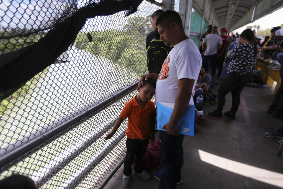 In this Oct. 10, 2019 photo, migrants wait for U.S. authorities to reopen a legal port of entry between Matamoros, Mexico, and Brownsville, Texas, after the bridge was closed briefly by U.S. authorities during a protest by migrants in Matamoros. Mexican gangs have adapted quickly to the new reality of masses of vulnerable migrants parking in the heart of their fiefdom, experts say, treating the travelers, often families with young children, like ATMs, ramping up kidnapping, extortion, and illegal crossings to extract money and fuel their empires. (AP Photo/Fernando Llano)