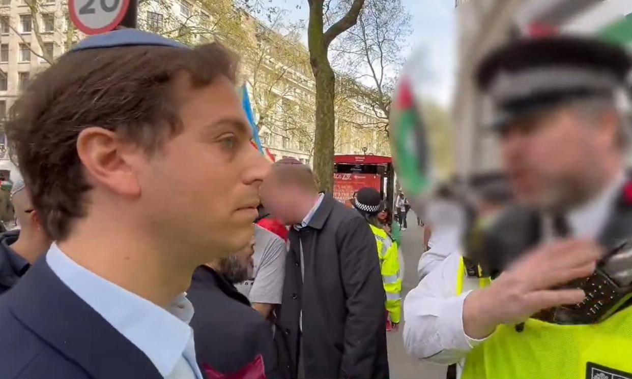 <span>Gideon Falter with a Metropolitan police officer during a pro-Palestine march in London on 13 April.</span><span>Photograph: Campaign Against Antisemitism/PA</span>