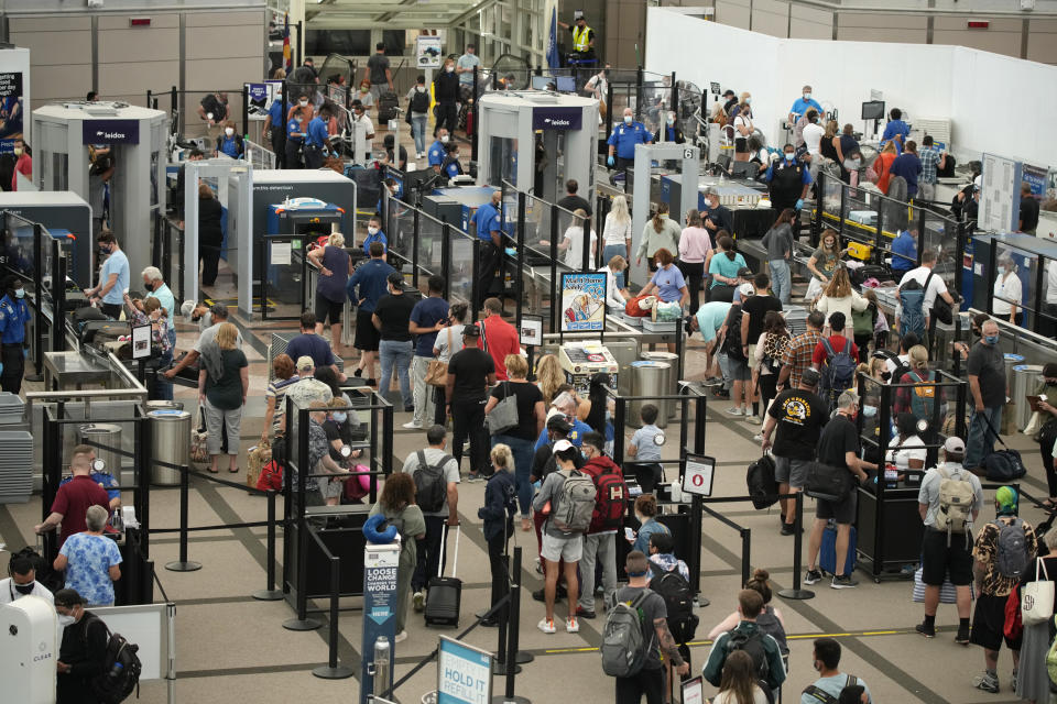 Travelers wear face coverings in the line for the north security checkpoint in the main terminal of Denver International Airport Tuesday, Aug. 24, 2021, in Denver. Two months after the Sept. 11, 2001 attacks, President George W. Bush signed legislation creating the Transportation Security Administration, a force of federal airport screeners that replaced the private companies that airlines were hiring to handle security. (AP Photo/David Zalubowski)