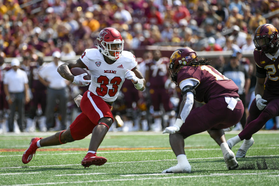 Miami-Ohio running back Kenny Tracy (33) runs past Minnesota defensive back Michael Dixon for a 12-yard gain and a first down in the second half of an NCAA college football game on Saturday, Sept. 11, 2021, in Minneapolis. Minnesota won 31-26. (AP Photo/Craig Lassig)