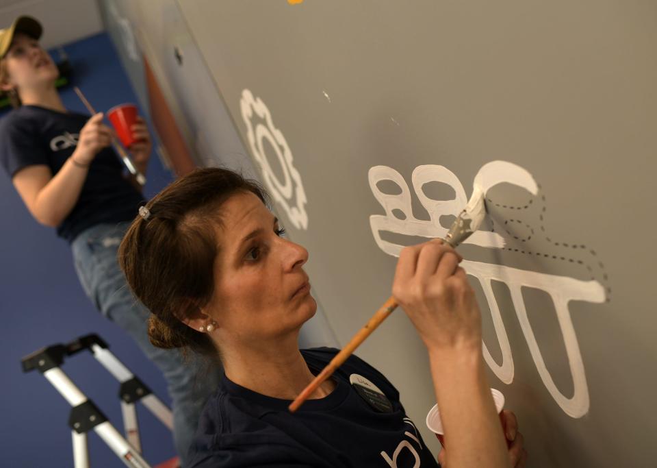 AbbVie employee Lisa Rinaldi paints the wall in the STEM lab. About 150 AbbVie volunteers from the Worcester facility showed up at Forest Grove Middle School to work on a greenhouse and enhance the STEM lab. The group was volunteering to help develop an immersive, large-scale STEM lab on the school’s campus Wednesday.