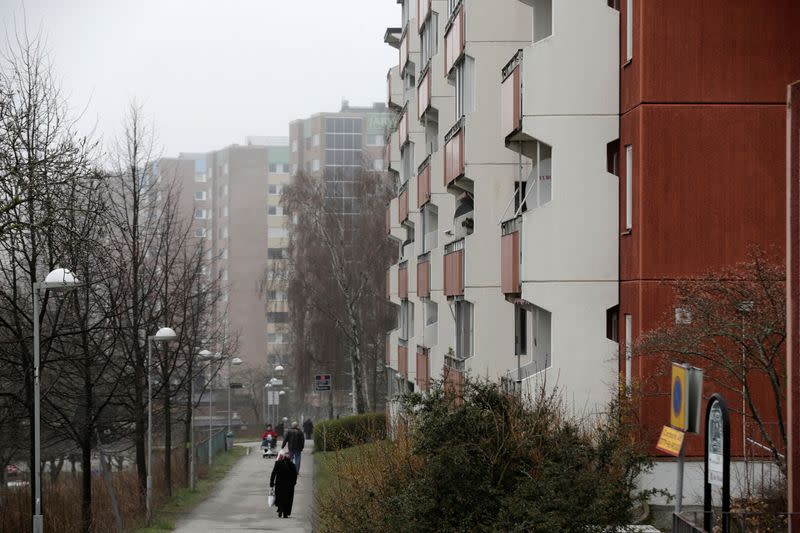 FILE PHOTO: People walk past apartment blocks in Stockholm