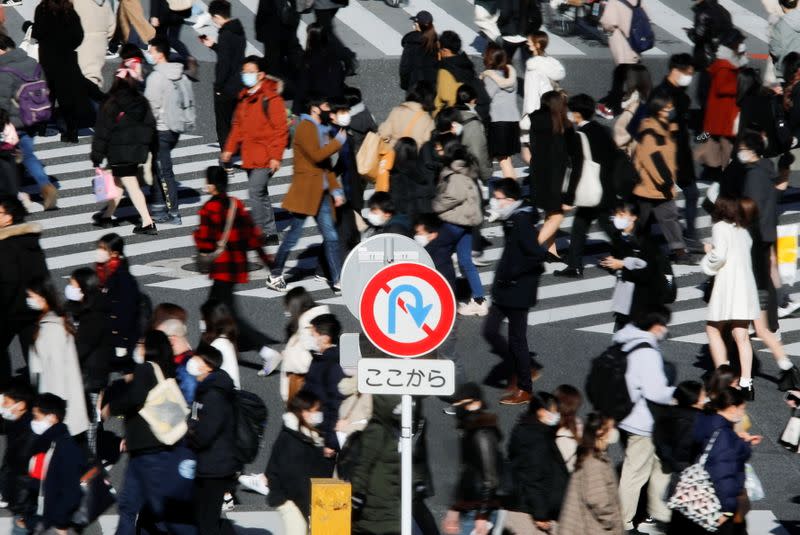 Passersby wearing protective face masks walks at Shibuya crossing amid coronavirus disease (COVID-19) outbreak in Tokyo