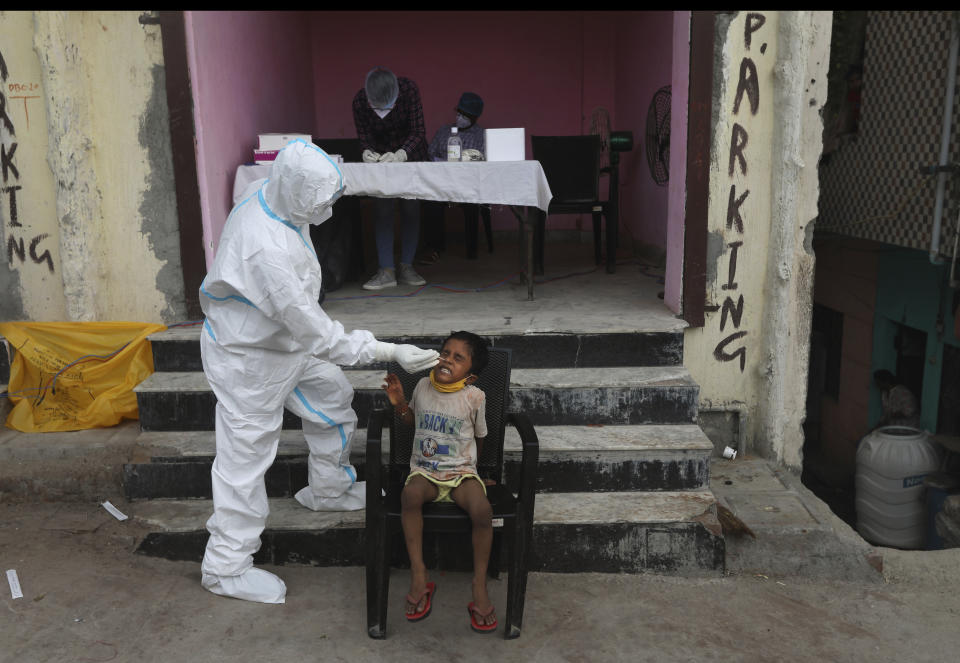 A health worker takes a nasal swab sample for COVID- 19 testing through rapid antigen methodology, in New Delhi, India , Friday, Aug. 7, 2020. As India hit another grim milestone in the coronavirus pandemic on Friday, crossing 2 million cases and more than 41,000 deaths, community health volunteers went on strike complaining they were ill-equipped to respond to the wave of infection in rural areas. (AP Photo/Manish Swarup)