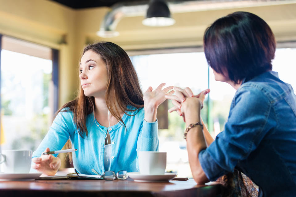 two people talking to each other at a coffee shop